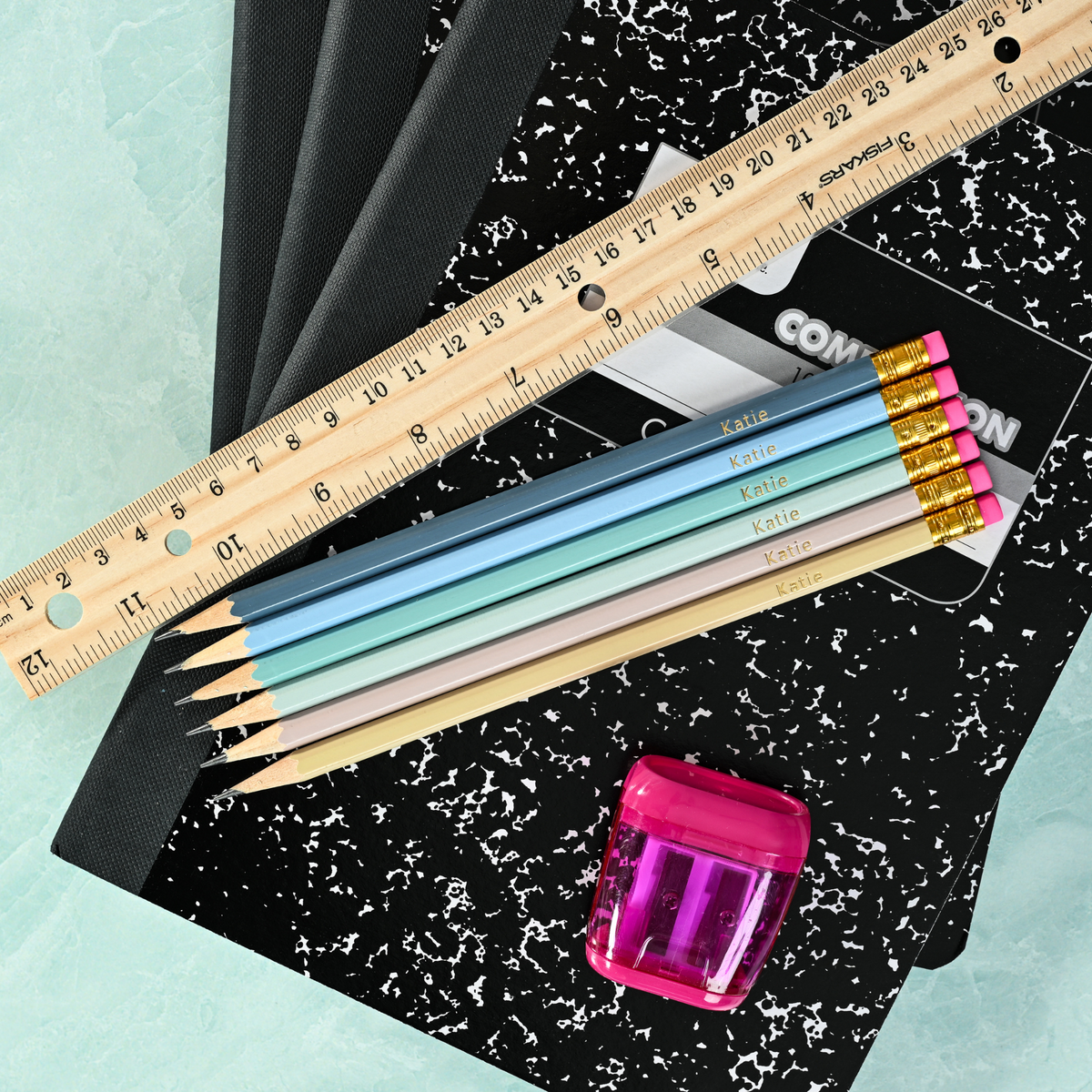 A set of customized pencils on top of a composition notebook