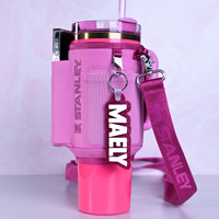 Personalized bag tags showing custom name engraving on durable acrylic with key ring attachment attached to a tumbler