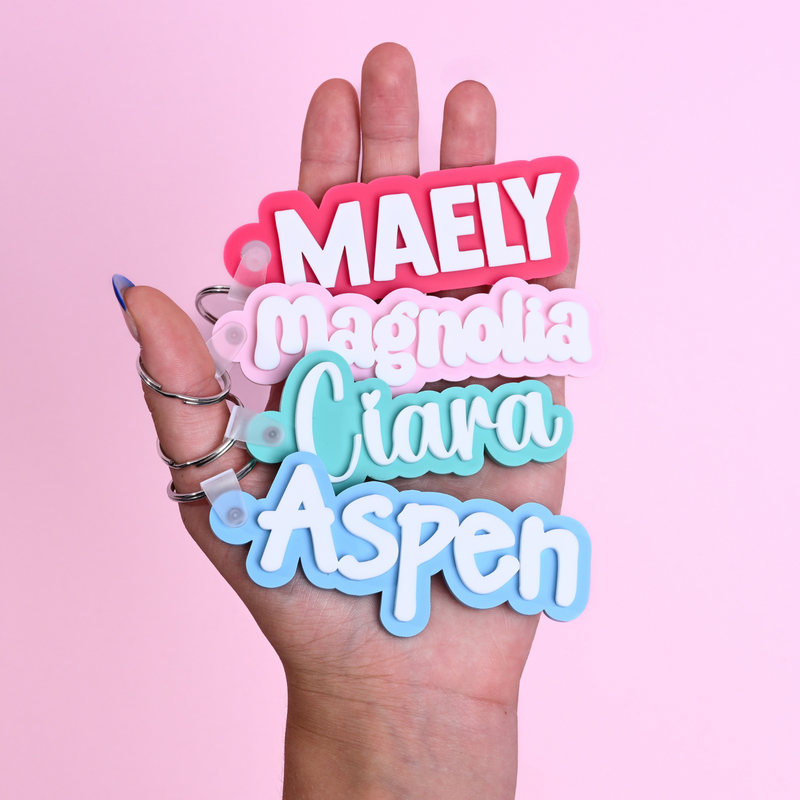 Personalized bag tags showing custom name engraving on durable acrylic with key ring attachment