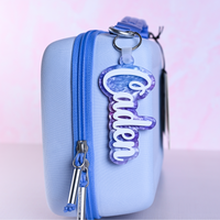 Personalized bag tags showing custom name engraving on durable acrylic with key ring attachment on a lunch box