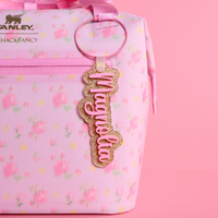 Love Shack Fancy Ibiza Sunset floral-patterned bag with a gold dust and bubblegum bag tag