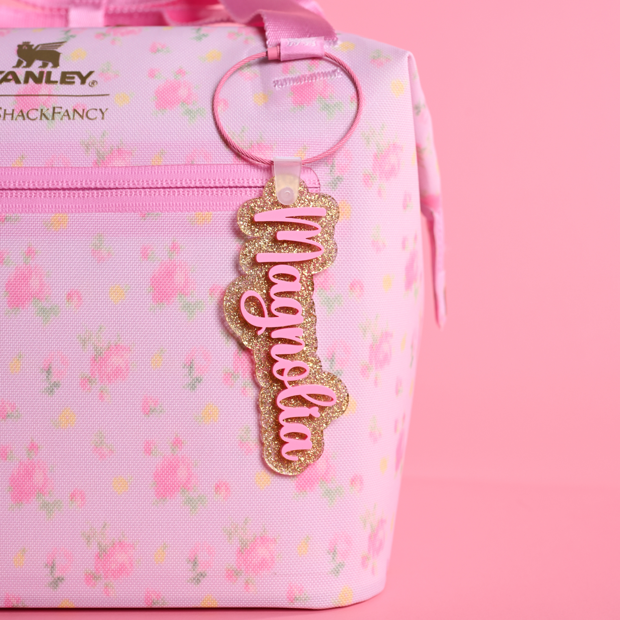 Love Shack Fancy Ibiza Sunset floral-patterned bag with a gold dust and bubblegum bag tag