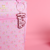 Love Shack Fancy Ibiza Sunset floral-patterned bag with a pink glitter and ballet pink bag tag