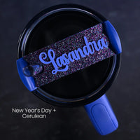 Blue tumbler accessory shown on top of a Stanley Quencher H2.0 tumbler personalized with 'Lasandra' name on a purple and blue glitter background
