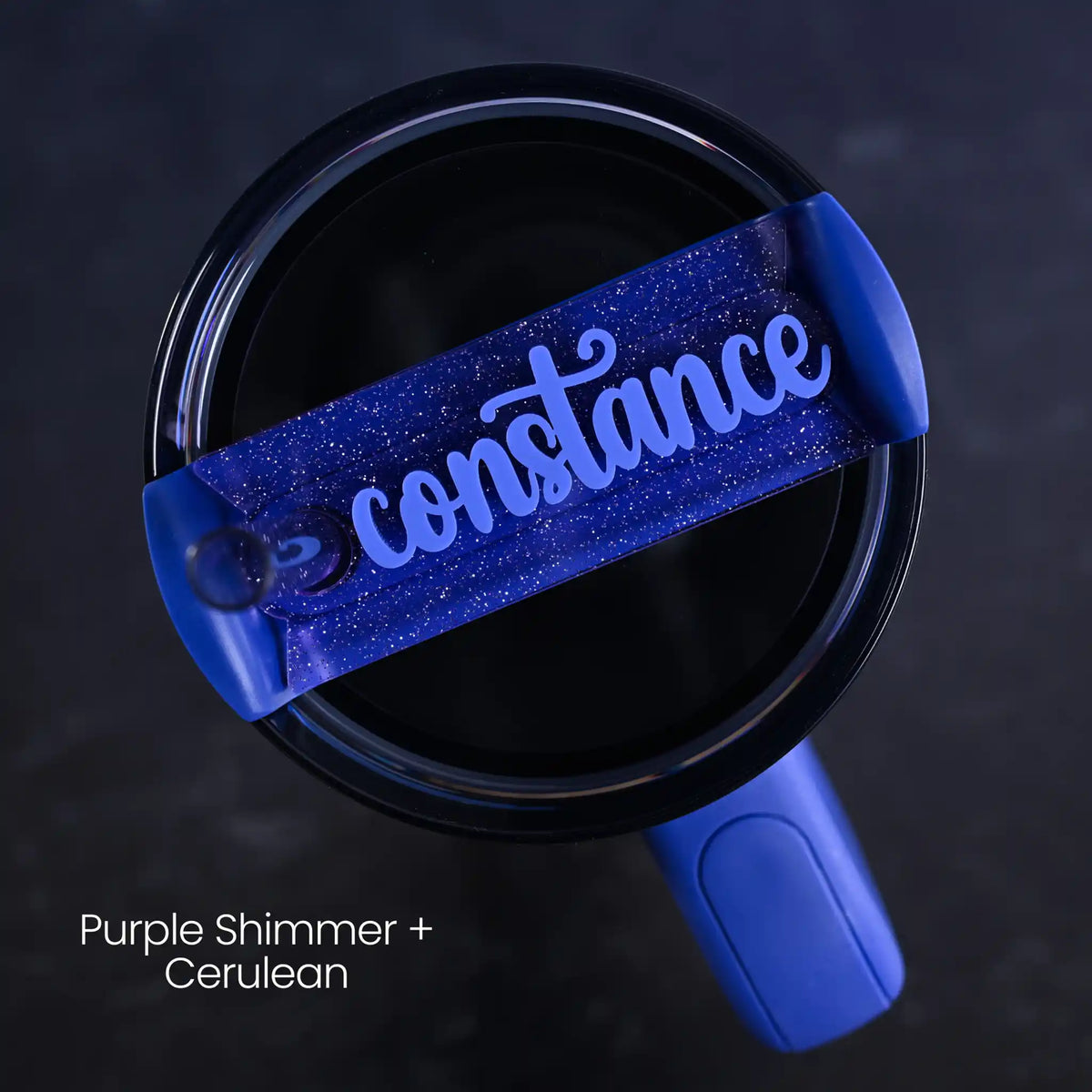 Blue tumbler accessory personalized with 'constance' name on a purple shimmer background