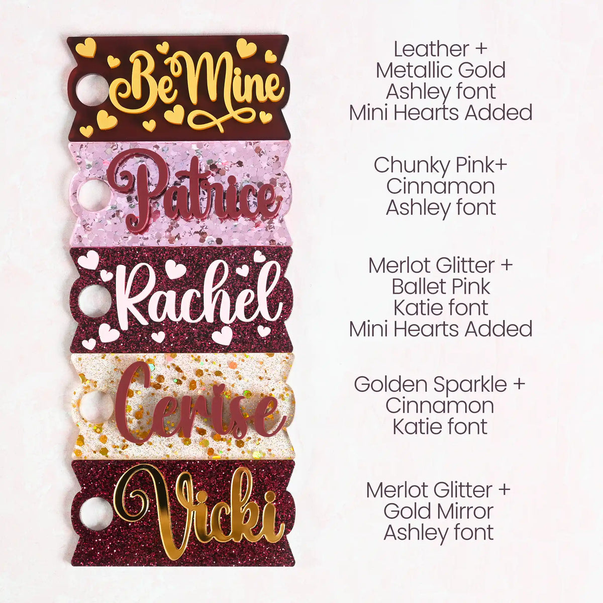 A collection of acrylic Topper Tag name plates designed for Stanley Quencher tumblers in burgundy, pink, and gold color tones.