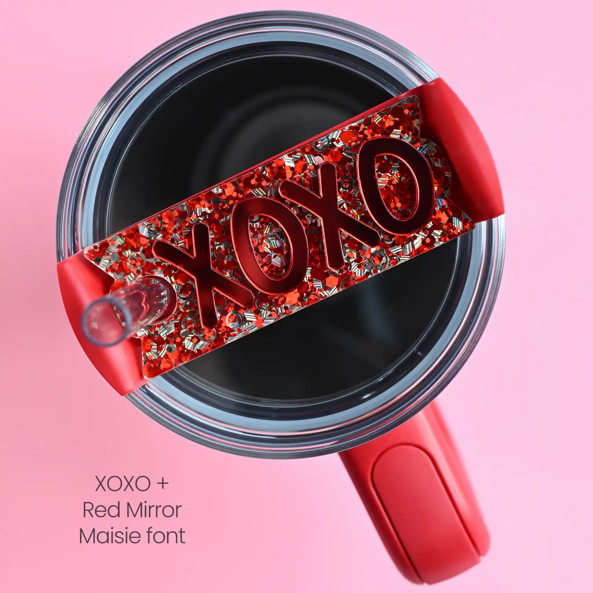 The top of a stanley tumbler shown with silver and red chunky glitter acrylic with the text XOXO written in bubble font in red mirror acrylic font.