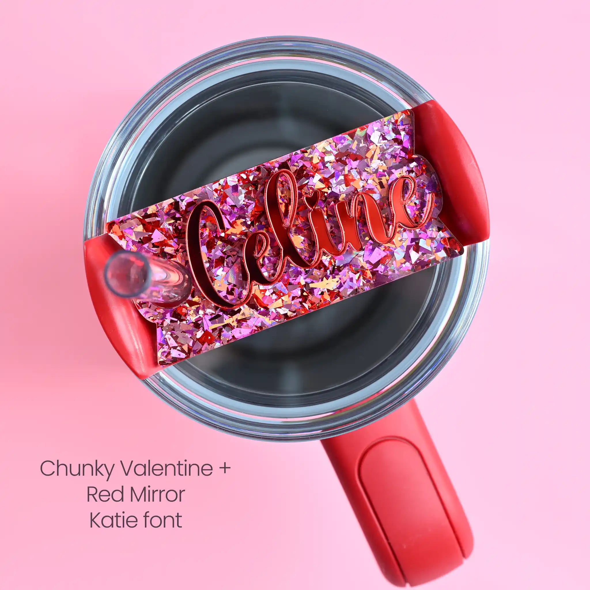 The top of a stanley tumbler shown with pink and red chunky glitter acrylic with the name Celine written in cursive in red mirror acrylic font.